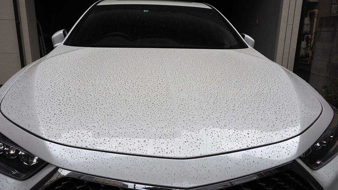 灰まじりの雨が降った後の白い車