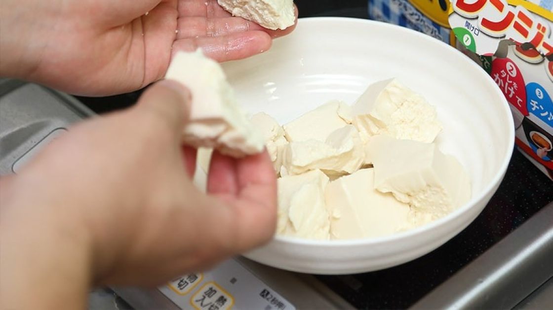 手で豆腐をほぐす写真