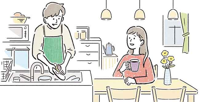 食器洗いする男性と、すぐ近くの食卓でお茶を飲んで休む女性