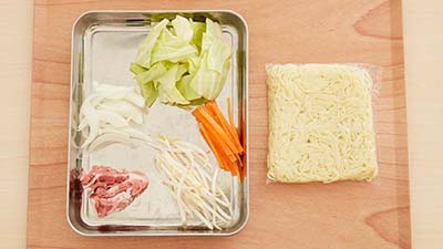 （1）野菜を食べやすい大きさに切る。玉ねぎは5mmくらいのくし型切り、にんじんは細切りにする。市販の炒めもの用のカット野菜（100g）を使ってもOK。