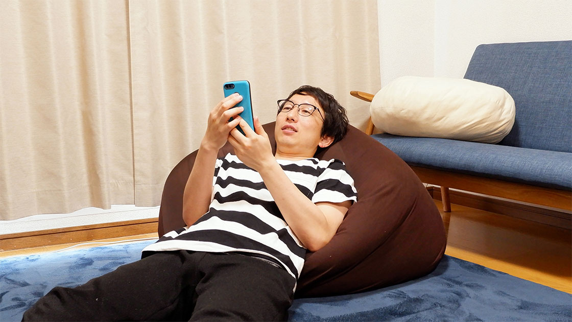 だらしない恰好で横たわるライター・斎藤充博