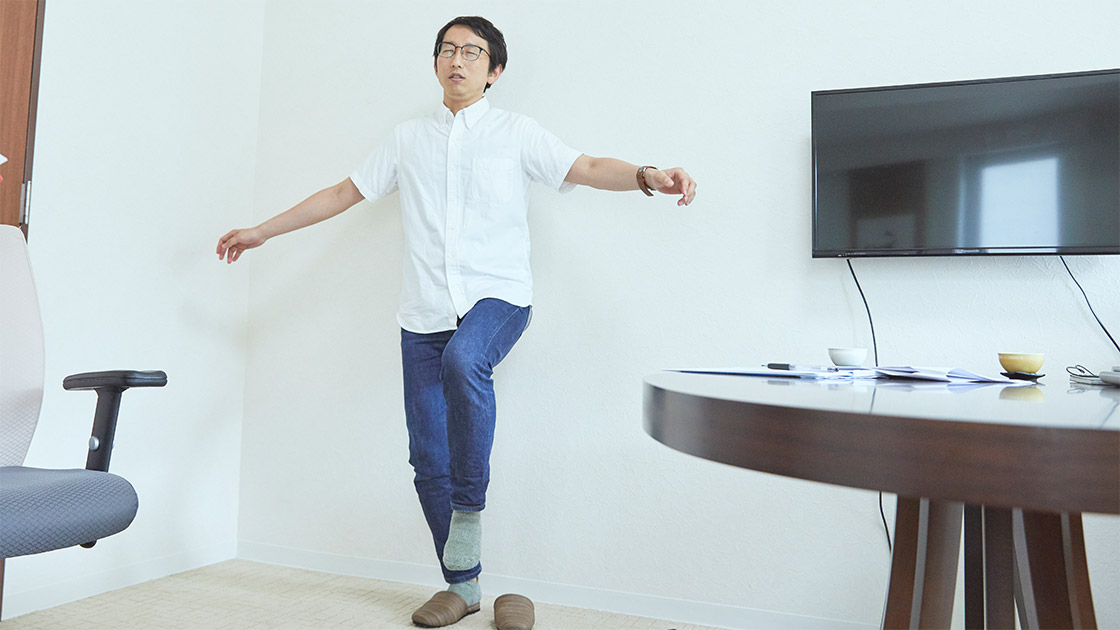 片足立ちをするライター・斎藤